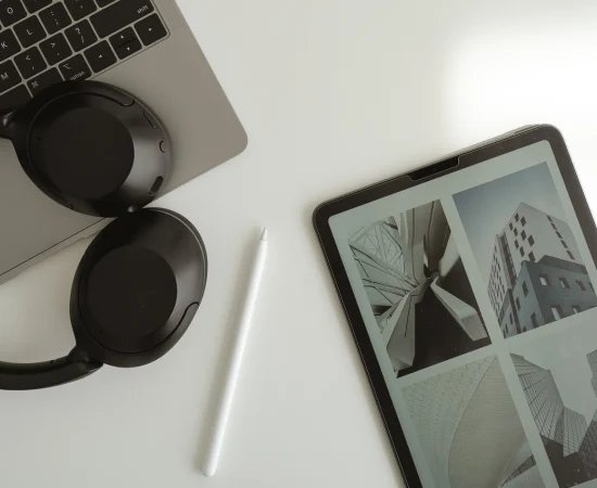 Tablet displaying design layouts with laptop, headphones, and stylus, symbolising Marketing Valley’s email marketing design process.