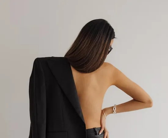 Woman wearing a black blazer draped over one shoulder, representing Marketing Valley’s bold and sophisticated social media management style.